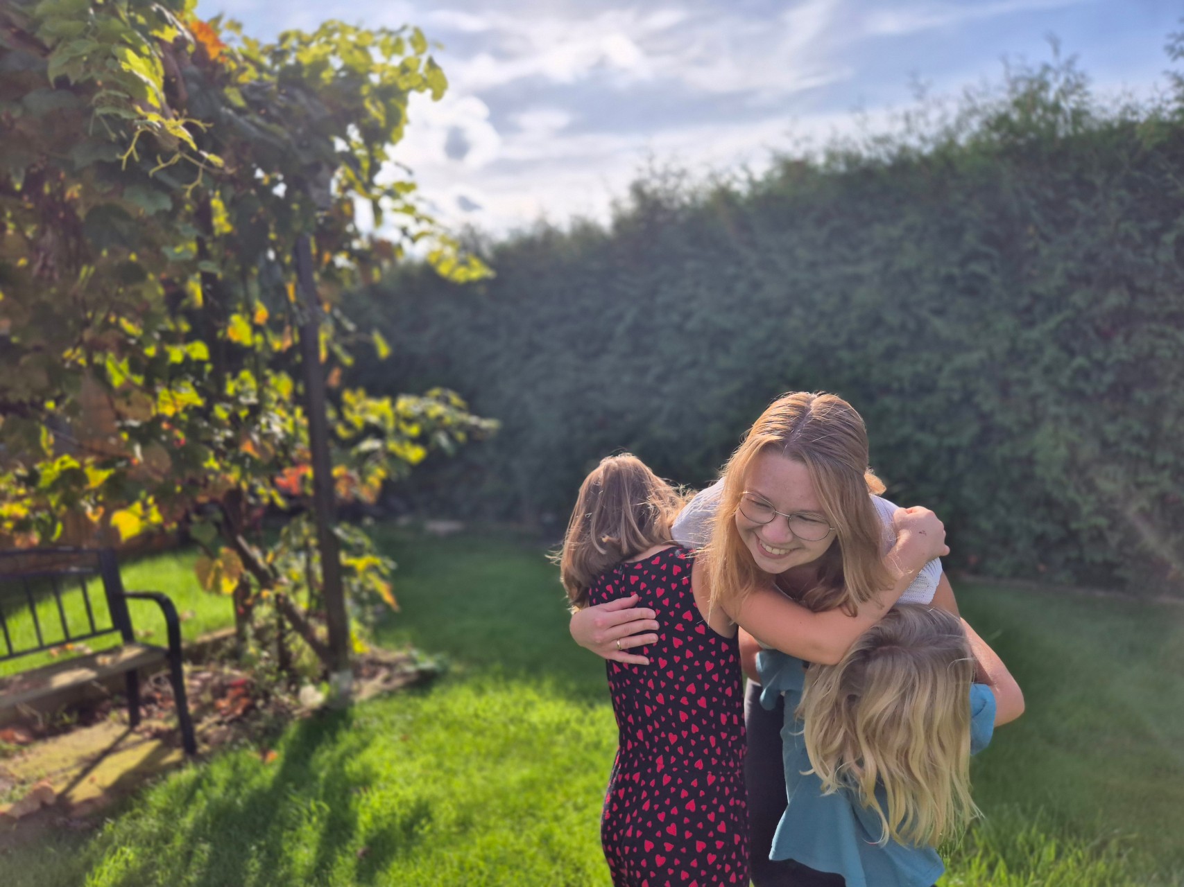Miriam umarmt ihre Kinder im Garten